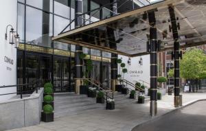 une façade de bâtiment avec des escaliers et des plantes en pot dans l'établissement Conrad Dublin, à Dublin