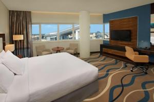 DoubleTree by Hilton Hotel and Residences Dubai – Al Barsha في دبي: غرفه فندقيه سرير وتلفزيون