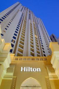 Ein großes Gebäude mit einem Schild auf dem Hügel. in der Unterkunft Hilton Dubai The Walk in Dubai