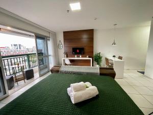 a bedroom with a bed with towels on a green rug at V608 Flat Amplo Aconchegante WI-FI Exclusivo in Brasilia +30 photos