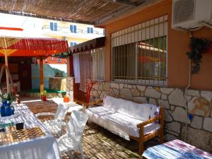 a patio with a couch and some tables and chairs at Vila Gjoka in Himare