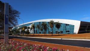 un gran edificio de cristal con palmeras delante en V510 Maravilhoso flat em Brasília Ótima localização en Brasilia