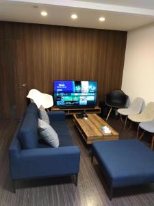 un soggiorno con divano blu e TV a schermo piatto di Tsunageru Aomori Yasukata - Vacation STAY 40732v ad Aomori