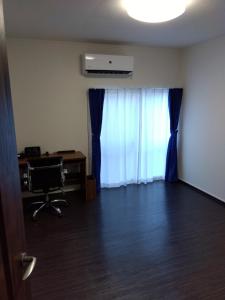 una stanza vuota con scrivania e finestra con tende blu di Tsunageru Aomori Yasukata - Vacation STAY 40732v ad Aomori
