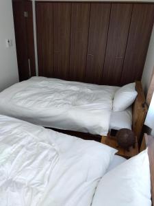 two beds in a room with white sheets and pillows at Tsunageru Aomori Yasukata - Vacation STAY 40732v in Aomori
