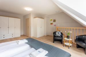 een slaapkamer met een groot bed en een stoel bij Ambria Apartments Ułańska in Świnoujście