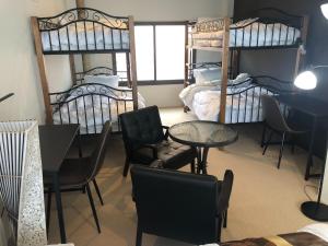 Habitación con 2 literas, mesa y sillas. en Cool Inn Otaru - Vacation STAY 42415v, en Otaru