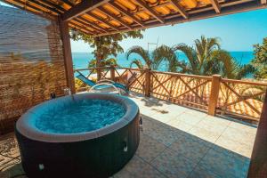 a hot tub on a patio with the ocean in the background at Altavista residence in Morro de São Paulo