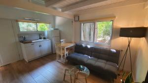 a living room with a couch and a kitchen at פינה בגינה יזרעאלי in ‘Amir