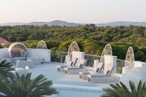 a patio with chairs and a view of the mountains at Conrad Algarve in Quinta do Lago