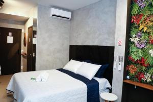ein Schlafzimmer mit einem Bett und einer Blumenwand in der Unterkunft C1 Estúdio VN1 - A 400 metros do Allianz Parque in São Paulo