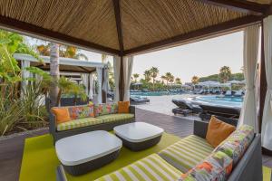 a porch with couches and a swimming pool at Conrad Algarve in Quinta do Lago