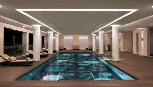 a large swimming pool in a hotel lobby at Conrad Algarve in Quinta do Lago