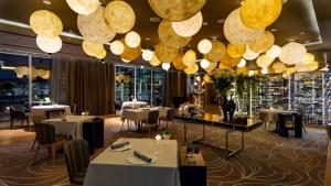 a restaurant with tables and chairs and large lights at Conrad Algarve in Quinta do Lago
