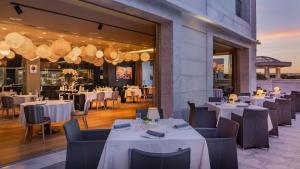 a restaurant with white tables and chairs and lights at Conrad Algarve in Quinta do Lago