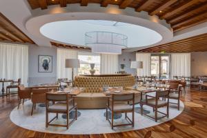 a restaurant with tables and chairs and a large ceiling at Conrad Algarve in Quinta do Lago