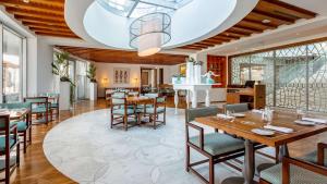 a dining room with wooden tables and chairs at Conrad Algarve in Quinta do Lago