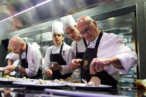 a group of chefs in a kitchen preparing food at Conrad Algarve in Quinta do Lago