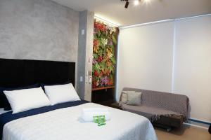 ein Schlafzimmer mit einem Bett und einem Wandgemälde in der Unterkunft C1 Estúdio VN1 - A 400 metros do Allianz Parque in São Paulo