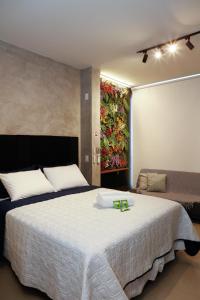 a bedroom with a large bed and a painting on the wall at C1 Estúdio VN1 - A 400 metros do Allianz Parque in Sao Paulo