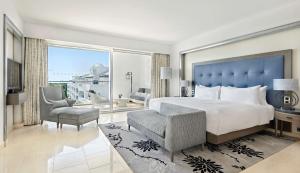 a bedroom with a large bed and a large window at Conrad Algarve in Quinta do Lago