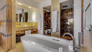 a bathroom with a tub and a sink and a mirror at Conrad Algarve in Quinta do Lago