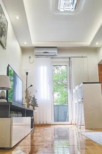 - un salon avec une fenêtre, une table et des chaises dans l'établissement River Site Lux Apartment, à Podgorica