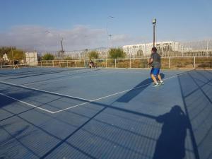 una sombra de un hombre parado en una pista de tenis en Departamento resort lagunas del mar, en La Serena