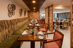 uma sala de jantar com mesas e cadeiras de madeira em Element by Westin Hotel Dar es Salaam em Dar es Salaam