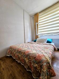 een slaapkamer met een bed en een raam met een sprei bij Clover Flower house in Istanbul