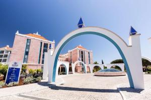 um arco em frente a um edifício com edifícios em Hilton Vilamoura em Vilamoura