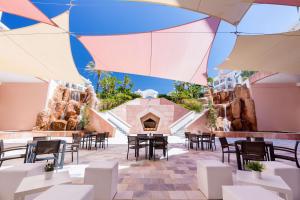 a patio with tables and chairs and a fireplace at Hilton Vilamoura in Vilamoura
