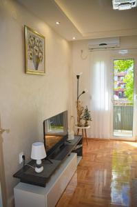 un salon avec une télévision à écran plat sur une table dans l'établissement River Site Lux Apartment, à Podgorica