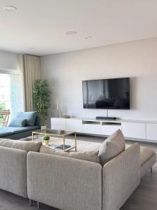 sala de estar con sofá y TV de pantalla plana en Douro Escape - Riverfront Apartment en Peso da Régua