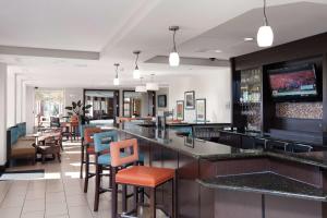 a bar in a restaurant with chairs and tables at Hilton Garden Inn Fargo in Fargo