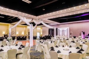 un salón de banquetes con mesas blancas y sillas blancas en Hilton Garden Inn Fargo en Fargo