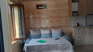 a bedroom with a bed and a wooden wall at Pchak Guesthouse B&B in Dsegh