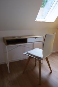 einen Schreibtisch mit einem Stuhl und einen Schreibtisch mit einem Fenster in der Unterkunft Lindenhuus in Fleckeby