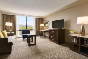 a hotel room with a desk and a television at Hilton Fort Collins in Fort Collins