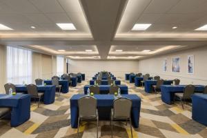 une salle de conférence avec des tables et des chaises bleues dans l'établissement Hilton Fort Collins, à Fort Collins