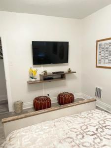 um quarto com uma televisão numa parede com duas almofadas em 2 Bedroom Apt - Stylish, Modern, And Convenient! em Pittsburgh