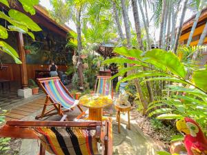 un patio con sillas, mesas y palmeras en Oasis Hostel en Granada