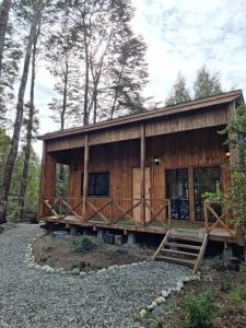 a large wooden cabin in the woods with trees at Cabaña Los Coihues in Puerto Montt