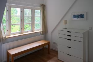 a bedroom with a dresser and a window at Lindenhuus in Fleckeby