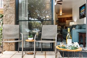 - 2 chaises et une bouteille de vin sur la terrasse dans l'établissement Kauhale Makai 108, à Kihei