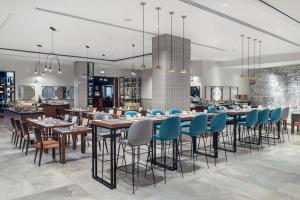 a dining room with tables and blue chairs at Hilton Gdansk in Gdańsk