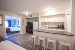 a kitchen with a counter and stools in a room at Stay Together Suites on The Strip - 1 Bedroom Apartment with View 656 in Las Vegas