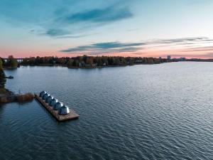a dock in the middle of a lake at sunset at Hilton Helsinki Kalastajatorppa in Helsinki
