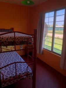 a bedroom with two bunk beds and a window at Cabañas AL-MA in Gualeguay