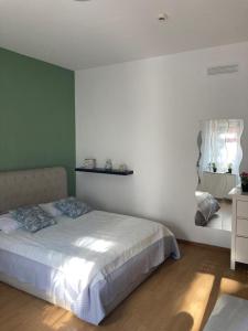 a bedroom with a white bed and a green wall at Terrace! in Rome